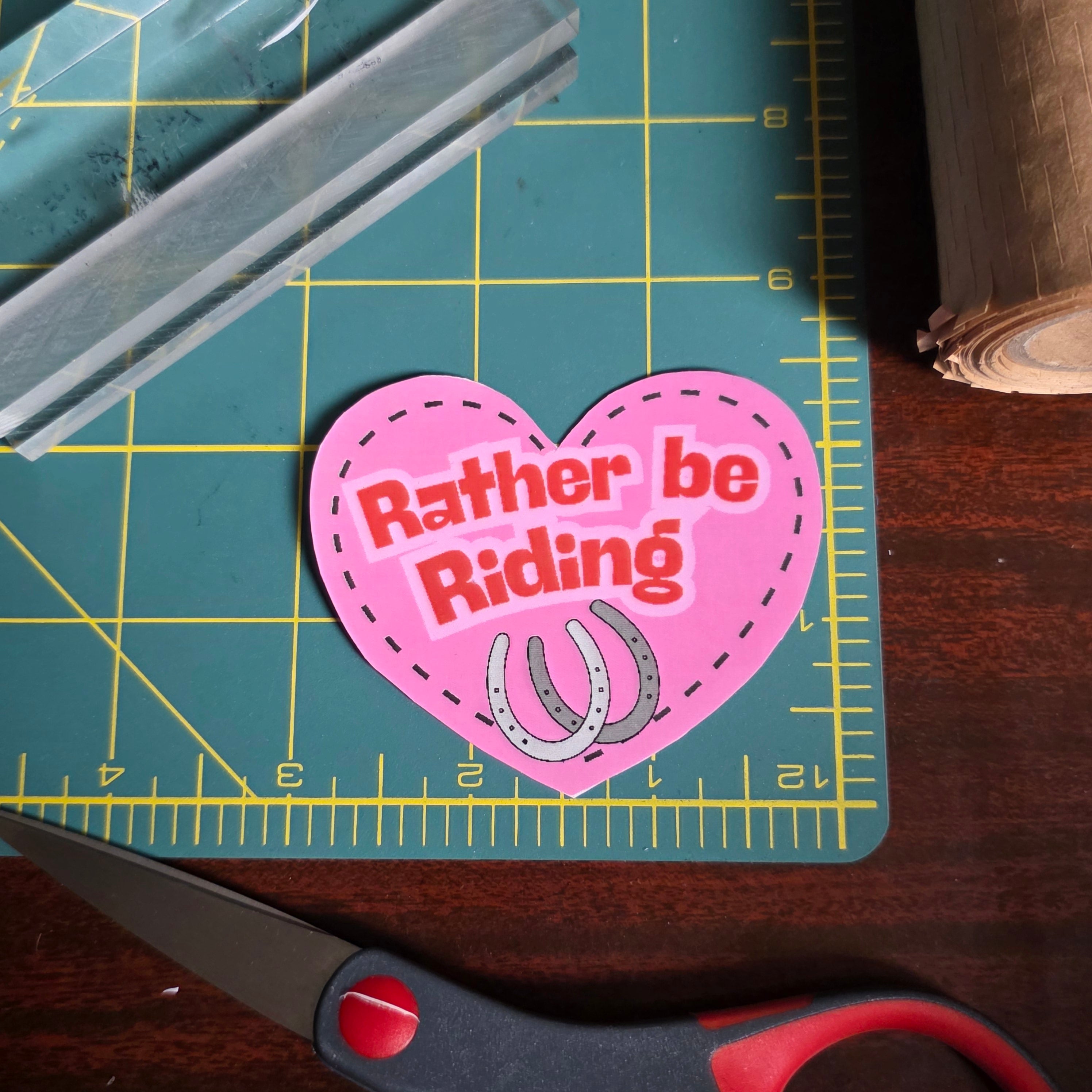 "Rather be Riding" heart sticker. 2.75 x 2.5 inches. Small size.