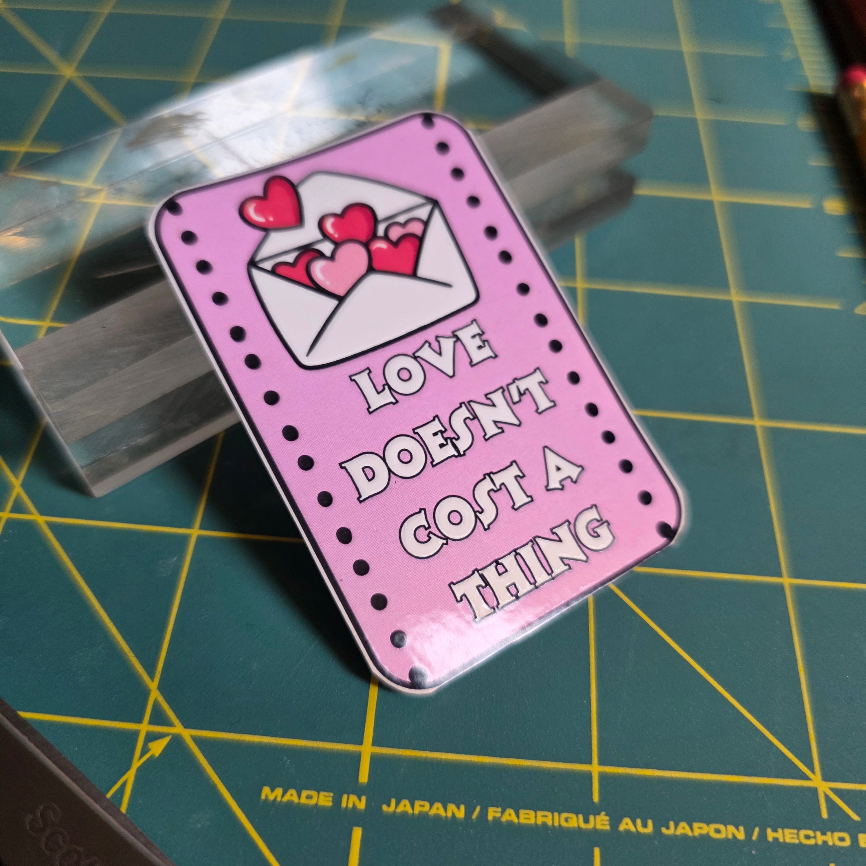 Love Doesn't Cost a Thing pink rectangular sticker.