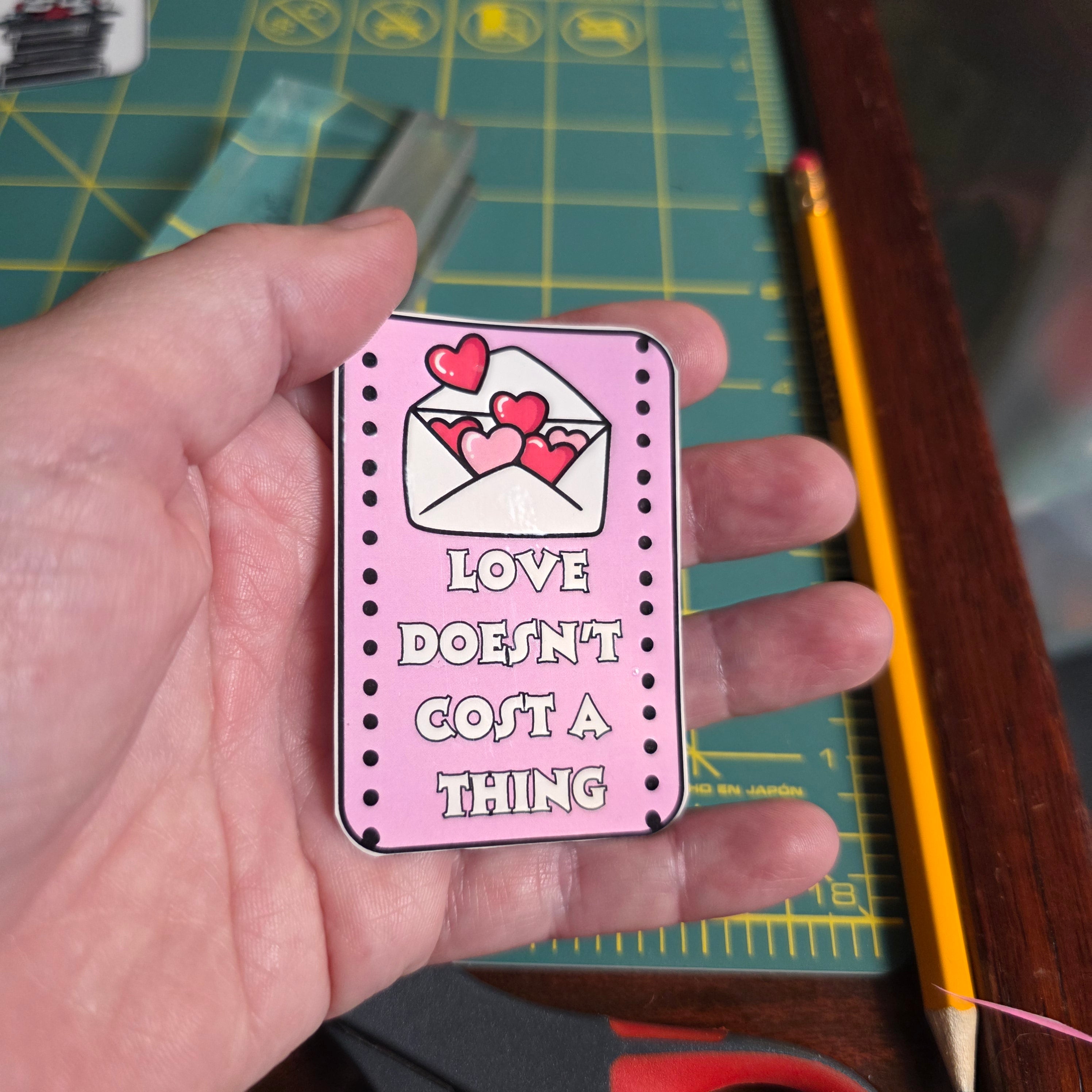 Love Doesn't Cost a Thing pink rectangular sticker.